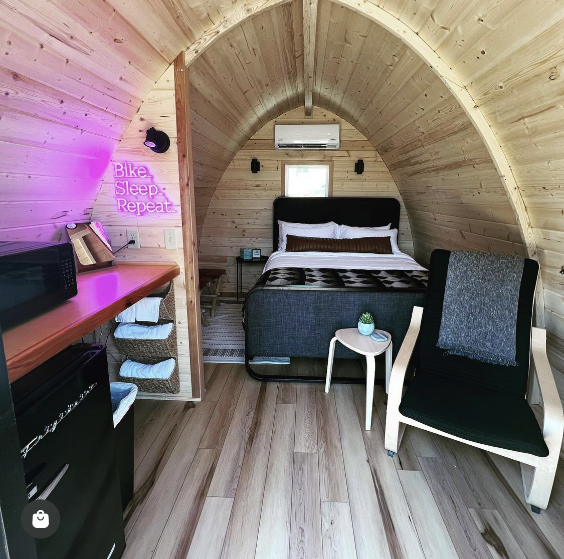 Inside a handcrafted glamping cabin with a queen bed at The Bike Inn