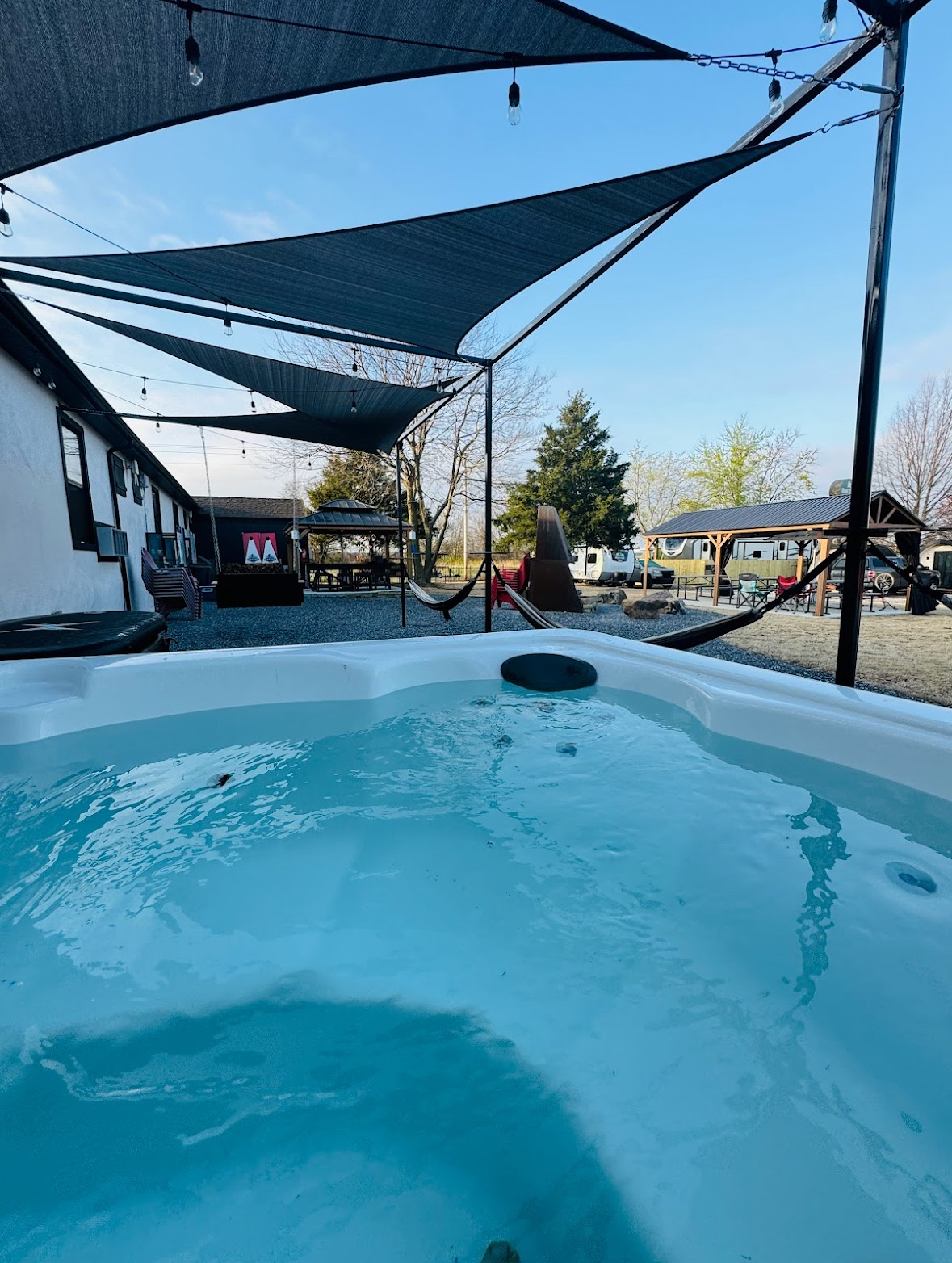 Outdoor hot tub under a shade sail at The Bike Inn, a boutique cycling hotel in Bentonville